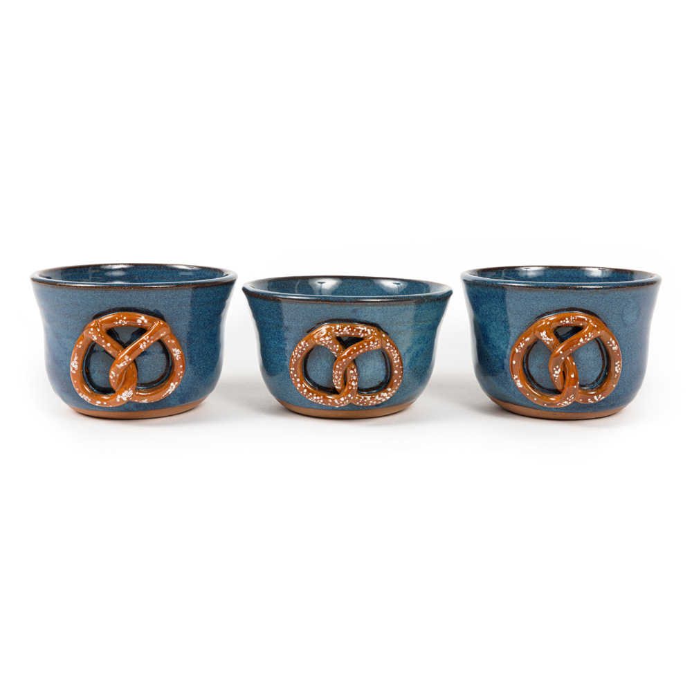 Three blue ceramic crocks decorated with a pretzel designs.