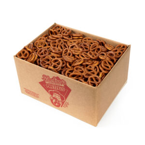 Open cardboard box containing small pretzels with no salt. The side of the box has red printed text and a logo.